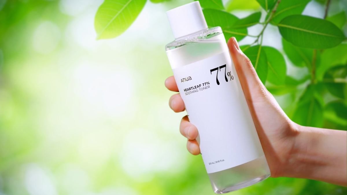 Hand holding ANUA 77% toner with leaves in background, depicting Exploring ANUA Embracing Natural Beauty in Korean Skincare.