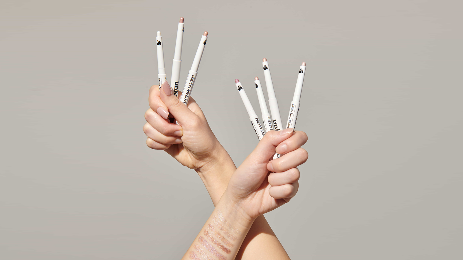 Hands holding multiple UNLEASHIA makeup pencils, showcasing Unleashing Beauty with UNLEASHIA: A Korean Makeup Brand Making Waves.