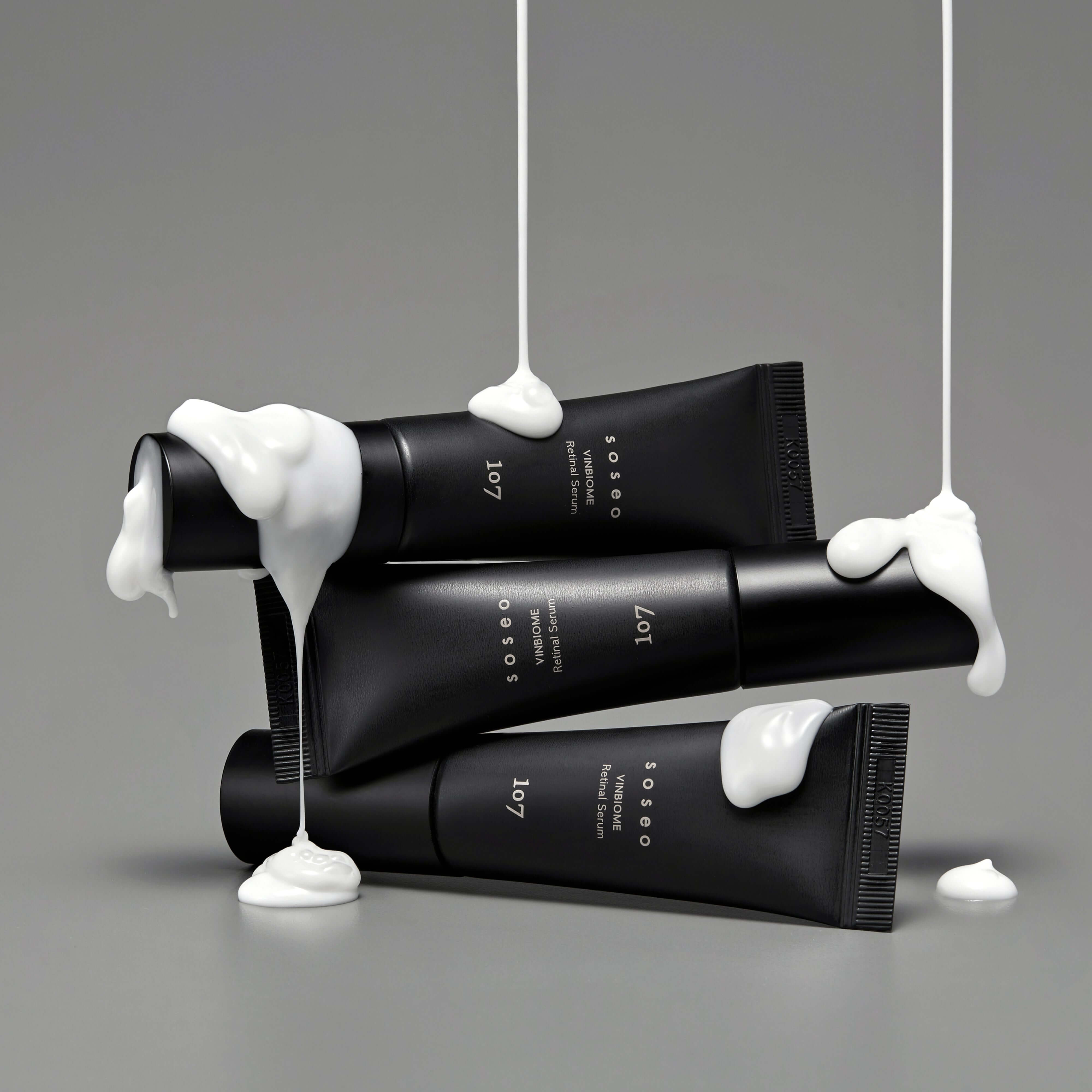 107 Soseo Vinbiome Retinal Serum 20ml on gray background with creamy texture drips, highlighting luxury skincare.