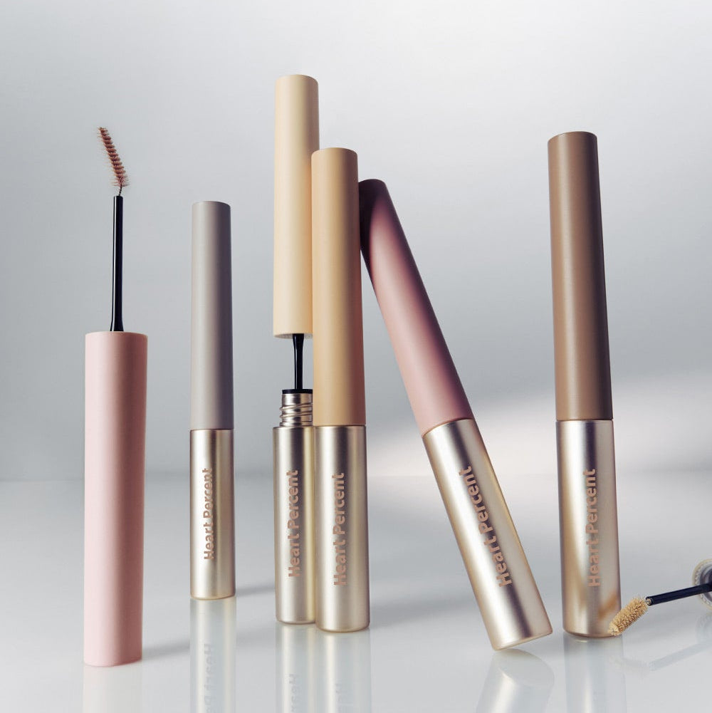 Assorted HEART PERCENT Dot On Mood Fake Up Brow Cara tubes in various shades on a reflective surface.