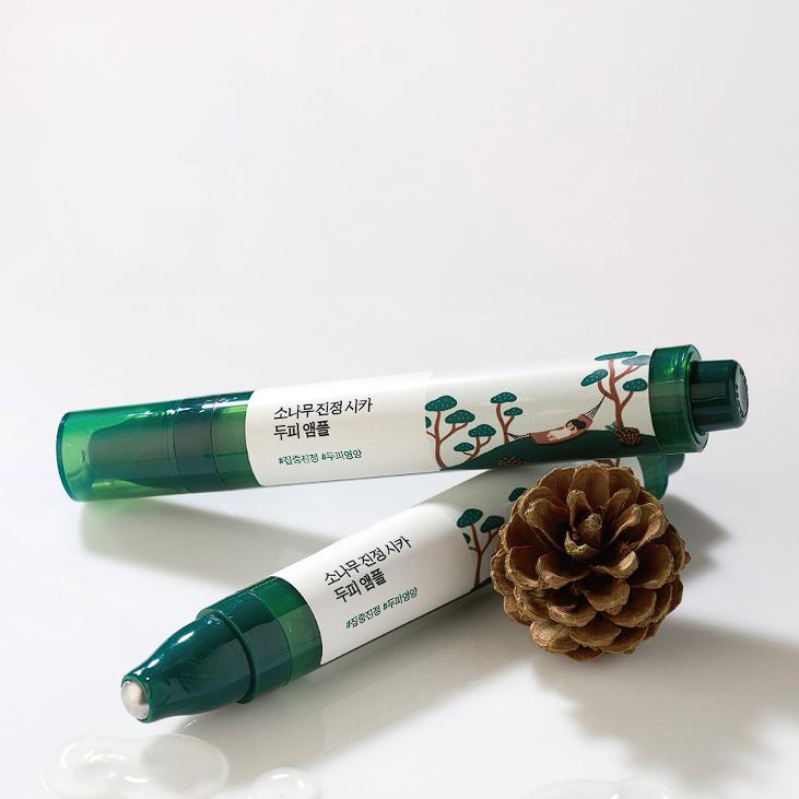 Two tubes of ROUND LAB Pine Soothing Cica Scalp Ampoule 15ml with pine cone on white background
