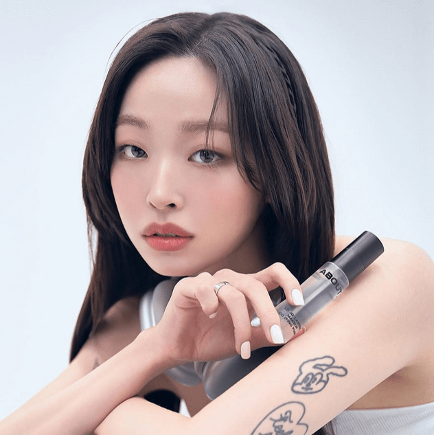 Person holding a bottle of ABOUT TONE Long Lasting Makeup Coating Fixer