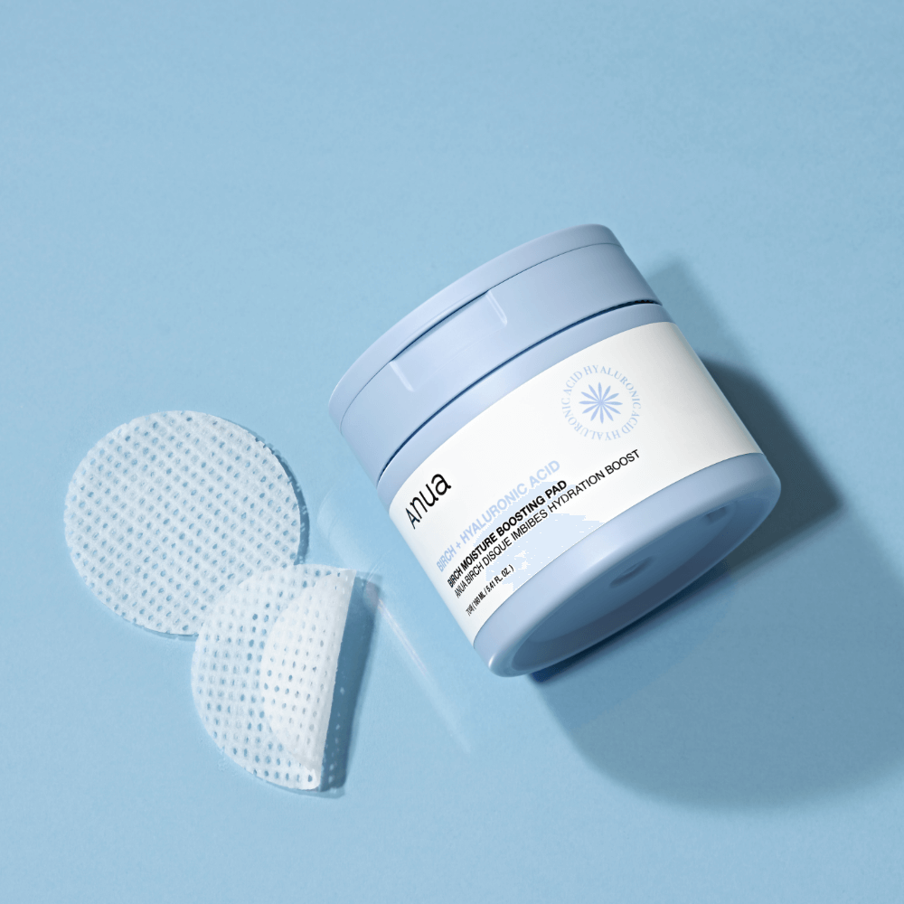 ANUA Birch + Hyaluron Moisture Boosting Pad 70p 160ml skincare product with exfoliating pads on blue background.