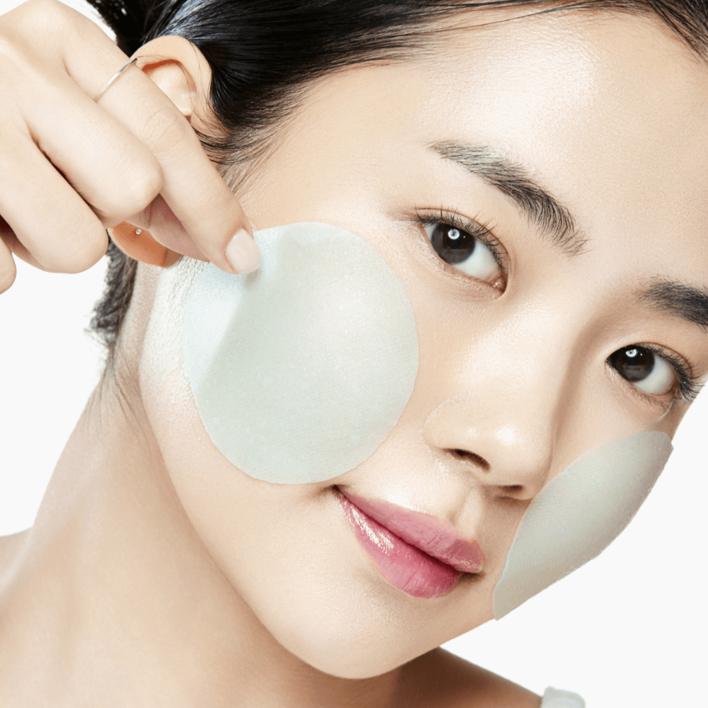 ANUA PDRN 100 Hyaluronic Acid Glow Pad applied on woman's cheek for skincare