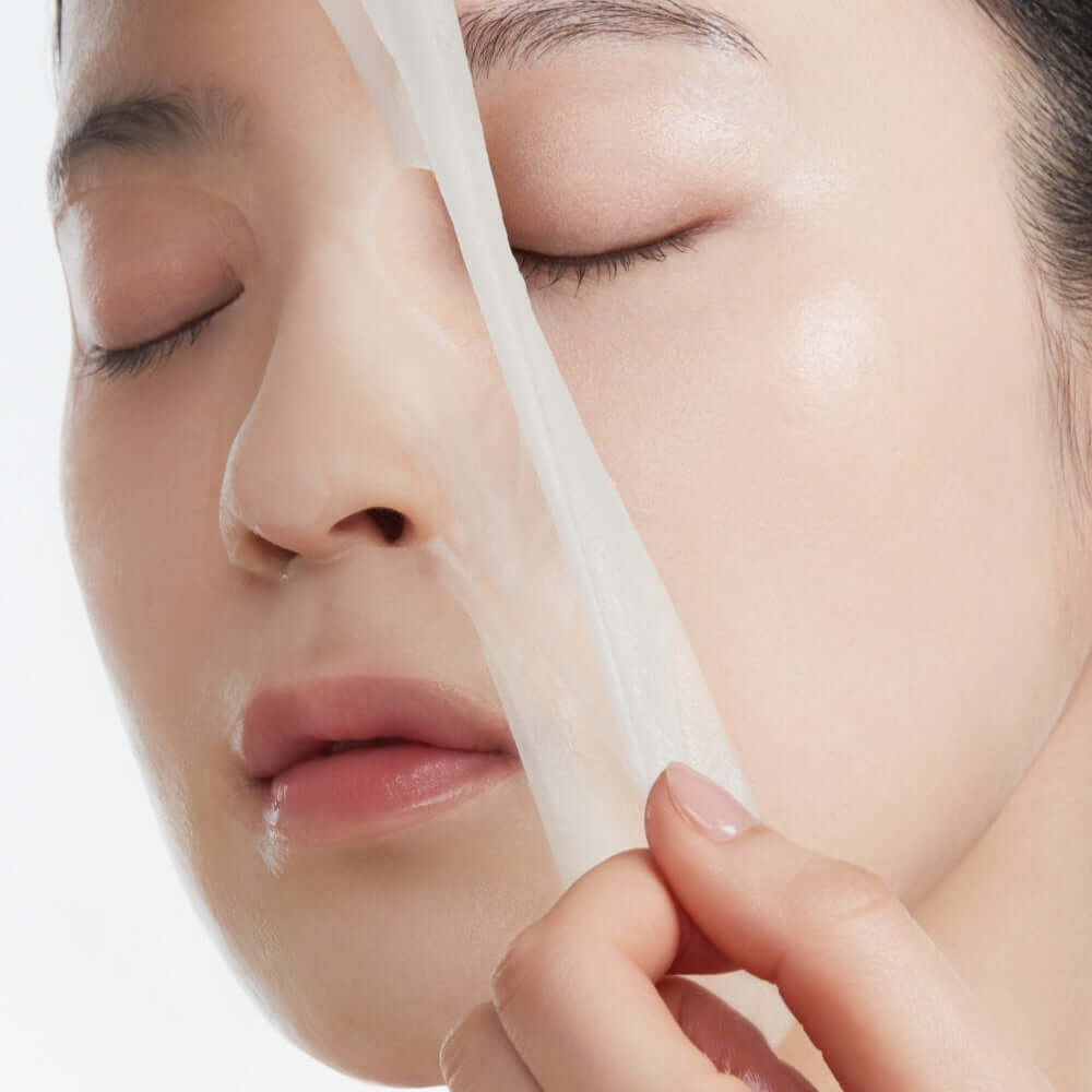 Person applying ANUA PDRN Hyaluronic Acid Capsule 100 Serum Mask for skincare treatment.