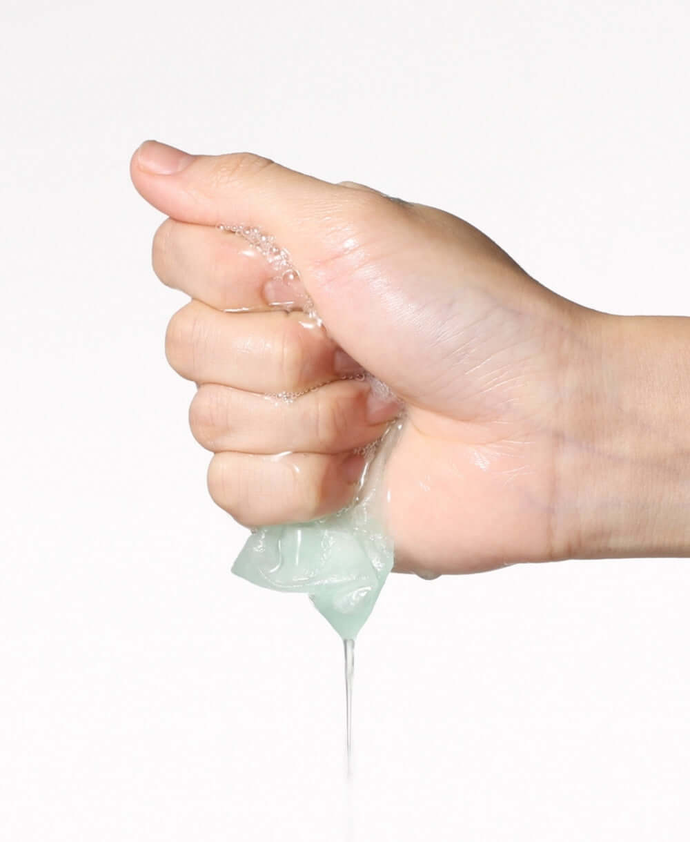 Hand squeezing ANUA PDRN Hyaluronic Acid Capsule 100 Serum Mask with serum dripping out for skincare nourishment