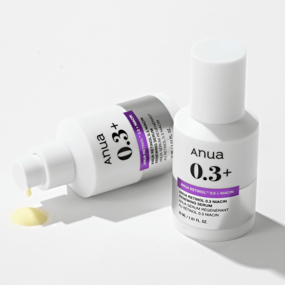 ANUA Retinol 0.3 Niacin Renewing Serum bottles with pump and spilled serum in white background