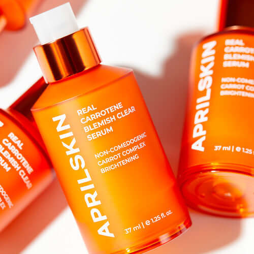 APRILSKIN Carrotene Clarifying Serum in orange bottle with brightening and non-comedogenic properties displayed on label.