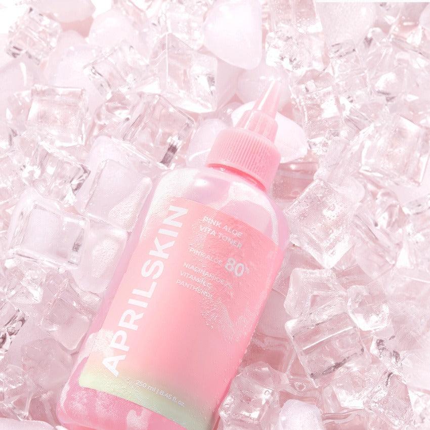 APRILSKIN Pink Aloe Vita Toner bottle surrounded by ice cubes, highlighting its refreshing and hydrating properties.