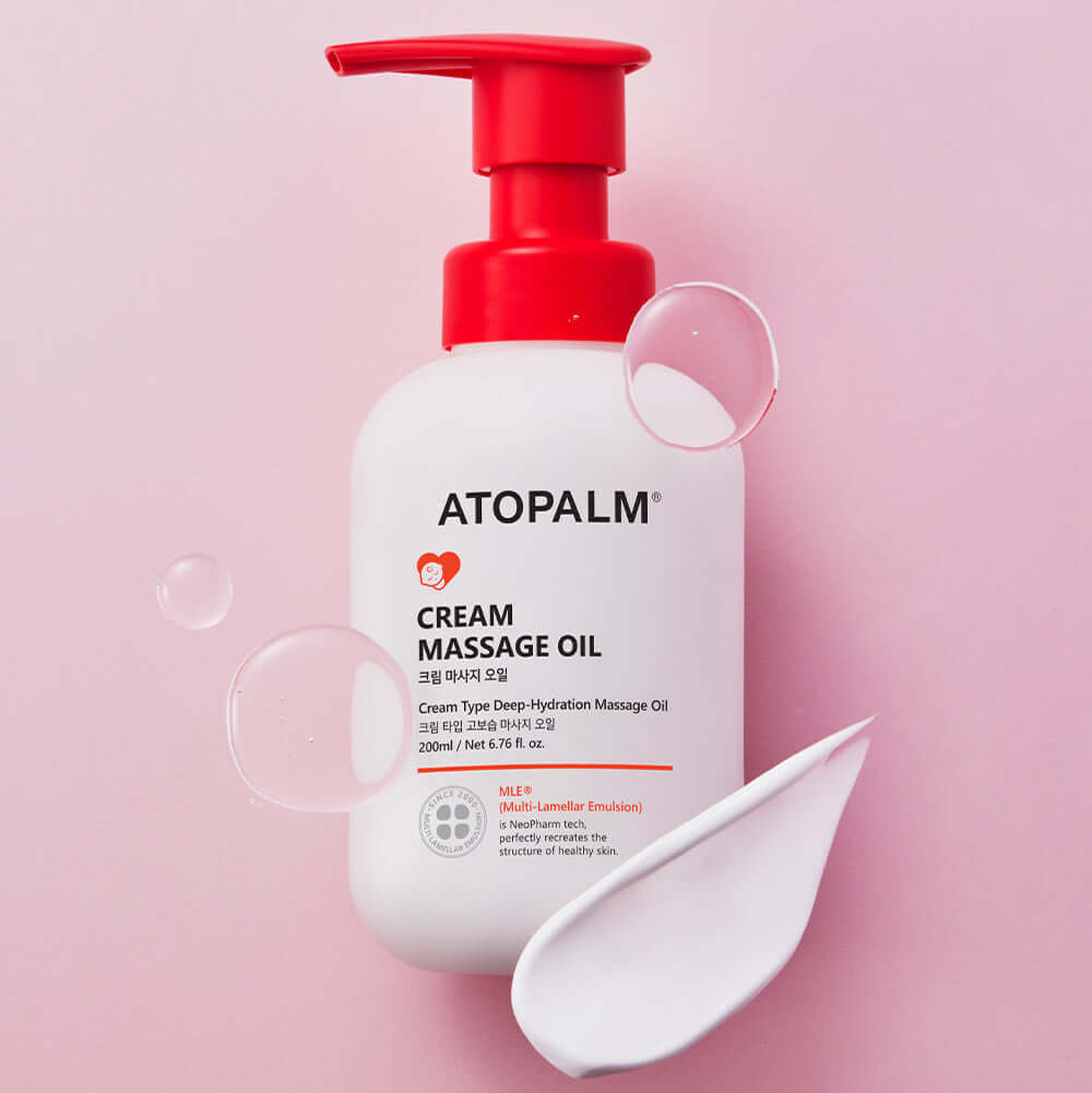 ATOPALM Cream Massage Oil 200ml bottle on a pink background with cream and oil droplets