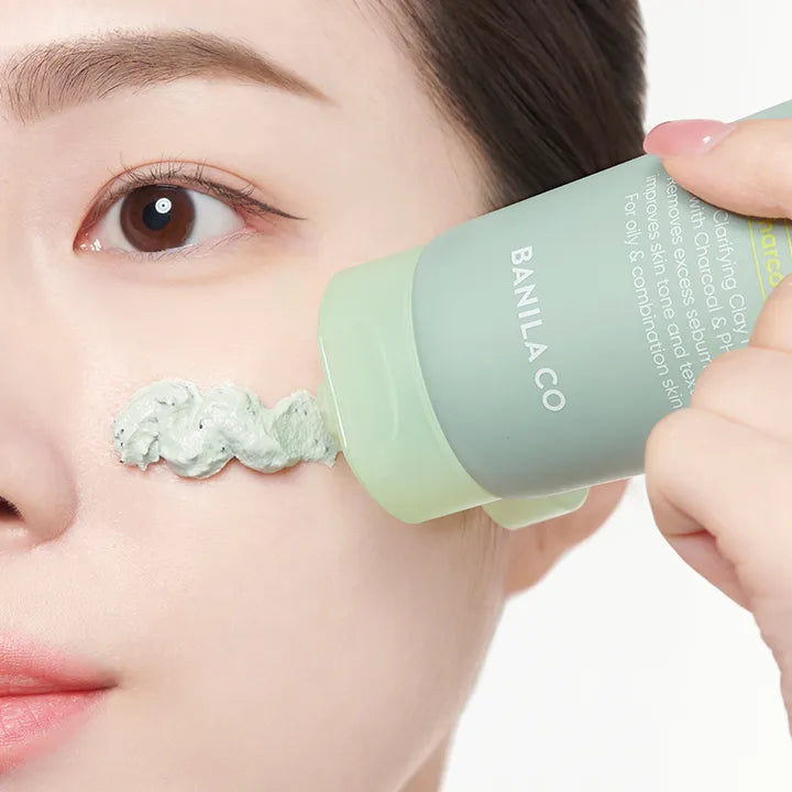 Applying BANILA CO Clean It Zero Charcoal Capsule Pore Clay Mask 100g on face for pore cleansing and skincare.