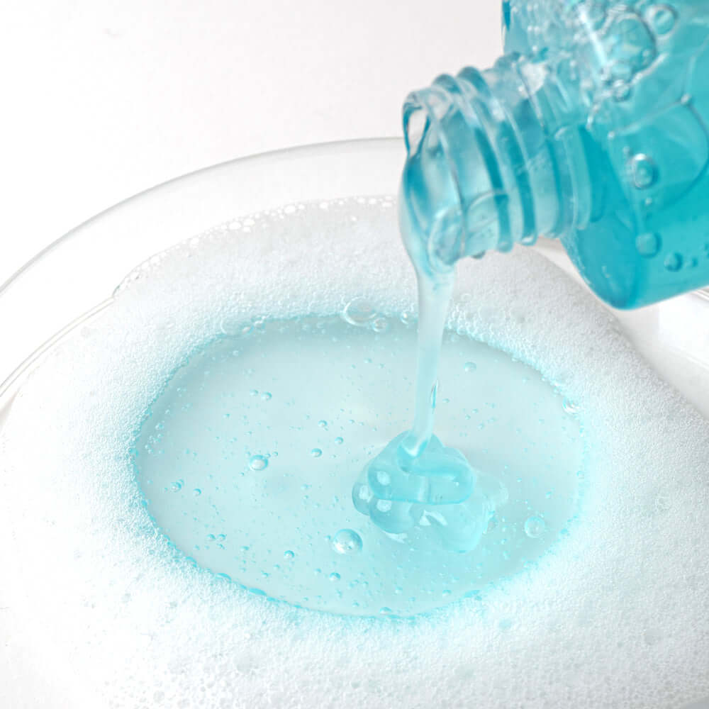 Pouring BARULAB 10-Hyaluronic Acid Blue Aqua Cleansing Gel into a bowl of bubbly foam, highlighting its hydrating properties