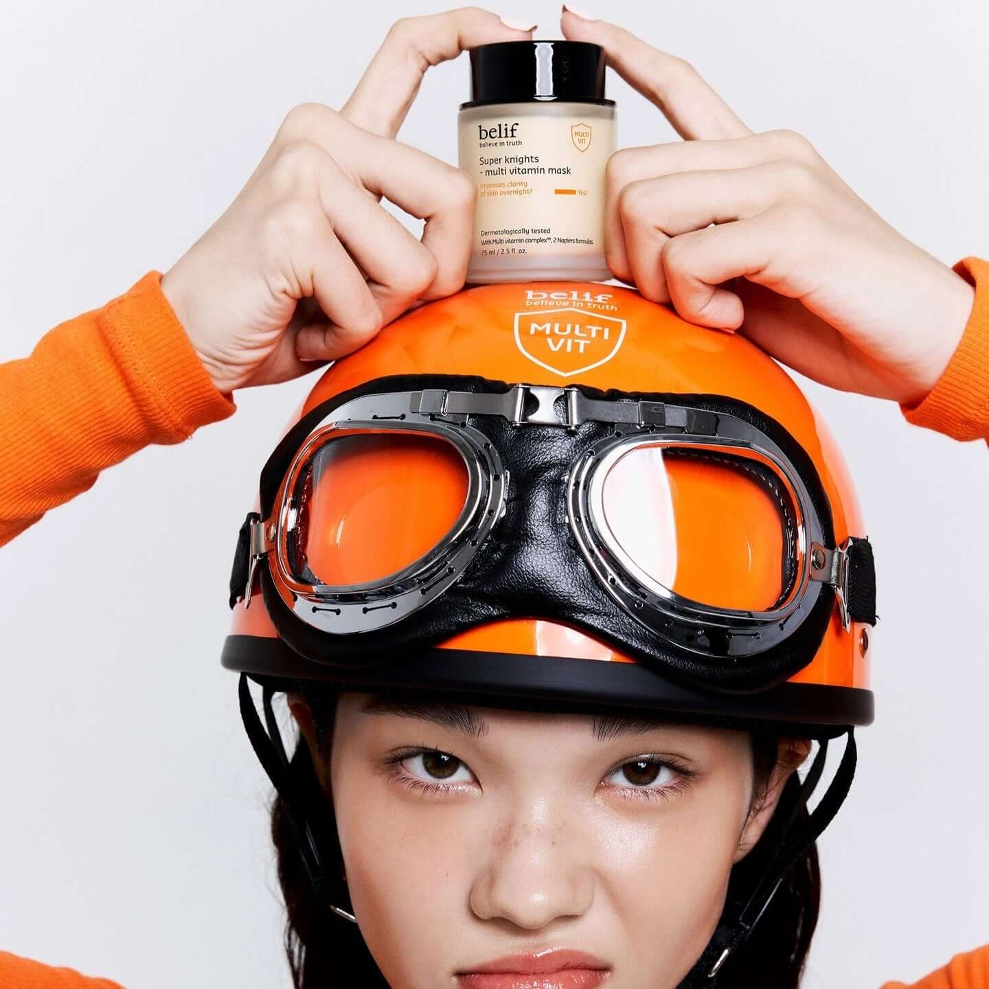Person holding BELIF Super Knights Multi Vitamin Mask 75ml on an orange helmet.