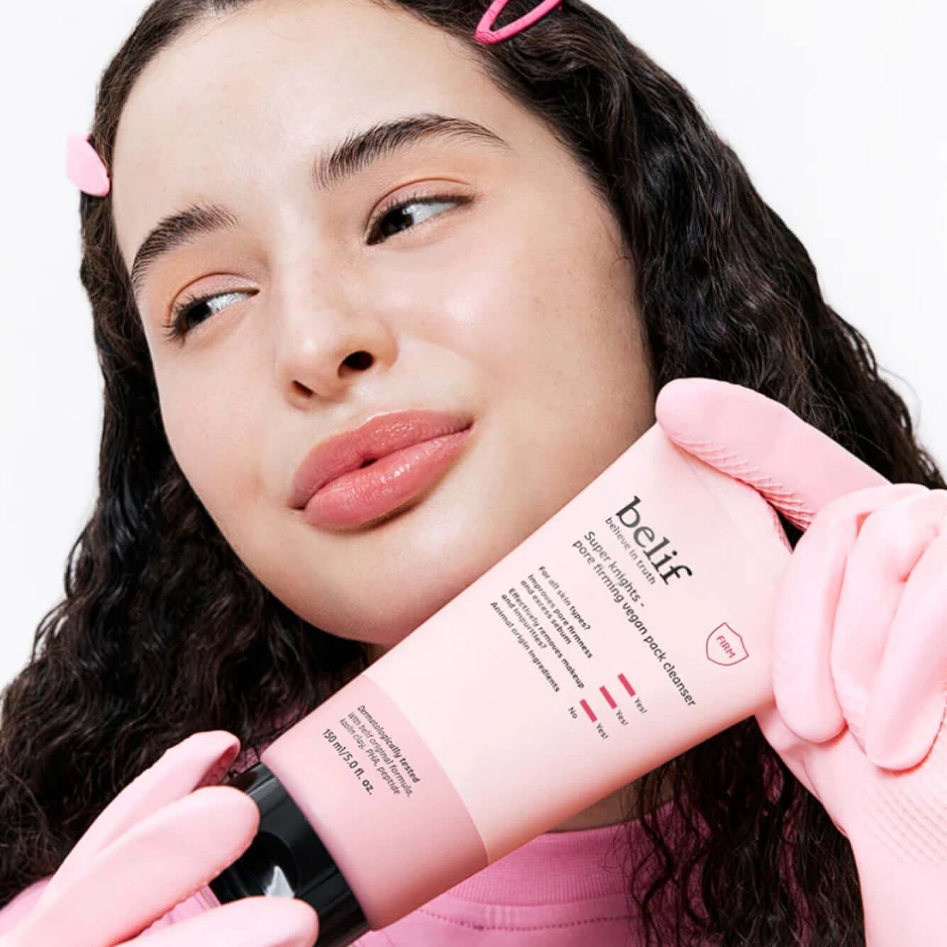 Woman holding BELIF Super Knights Pore Fiming Vegan Pack Cleanser 150ml, highlighting the skincare product in a pink package.