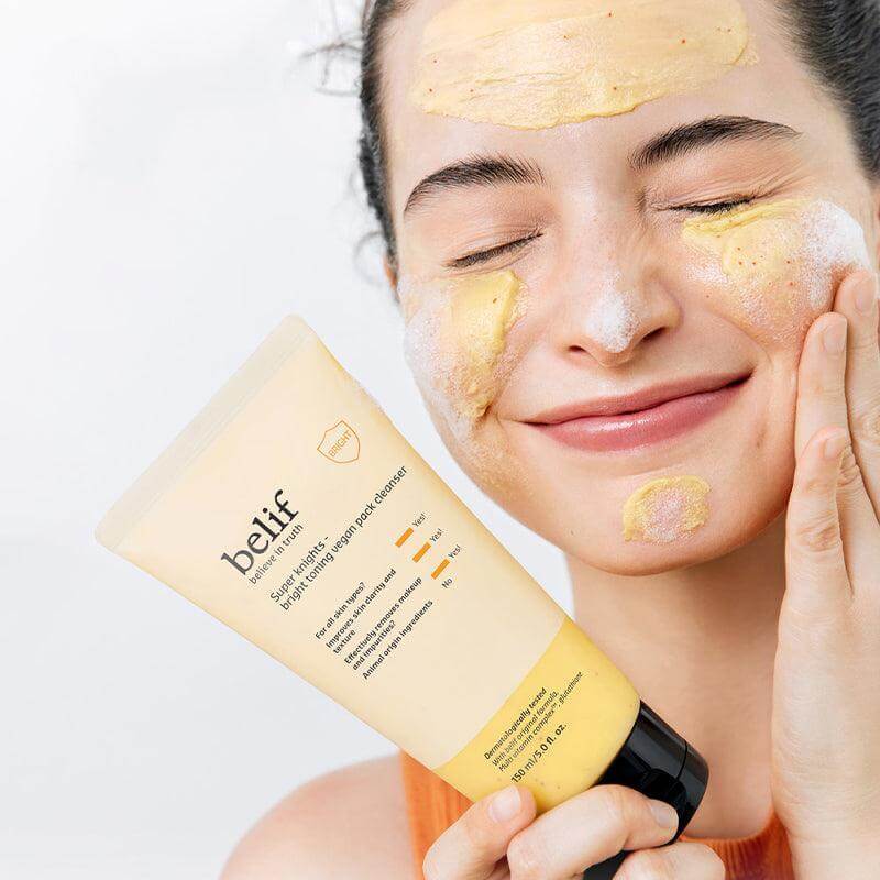 Woman applying BELIF Super Knights bright Toning Vegan Pack Cleanser 150ml to her face, showing the product in use.
