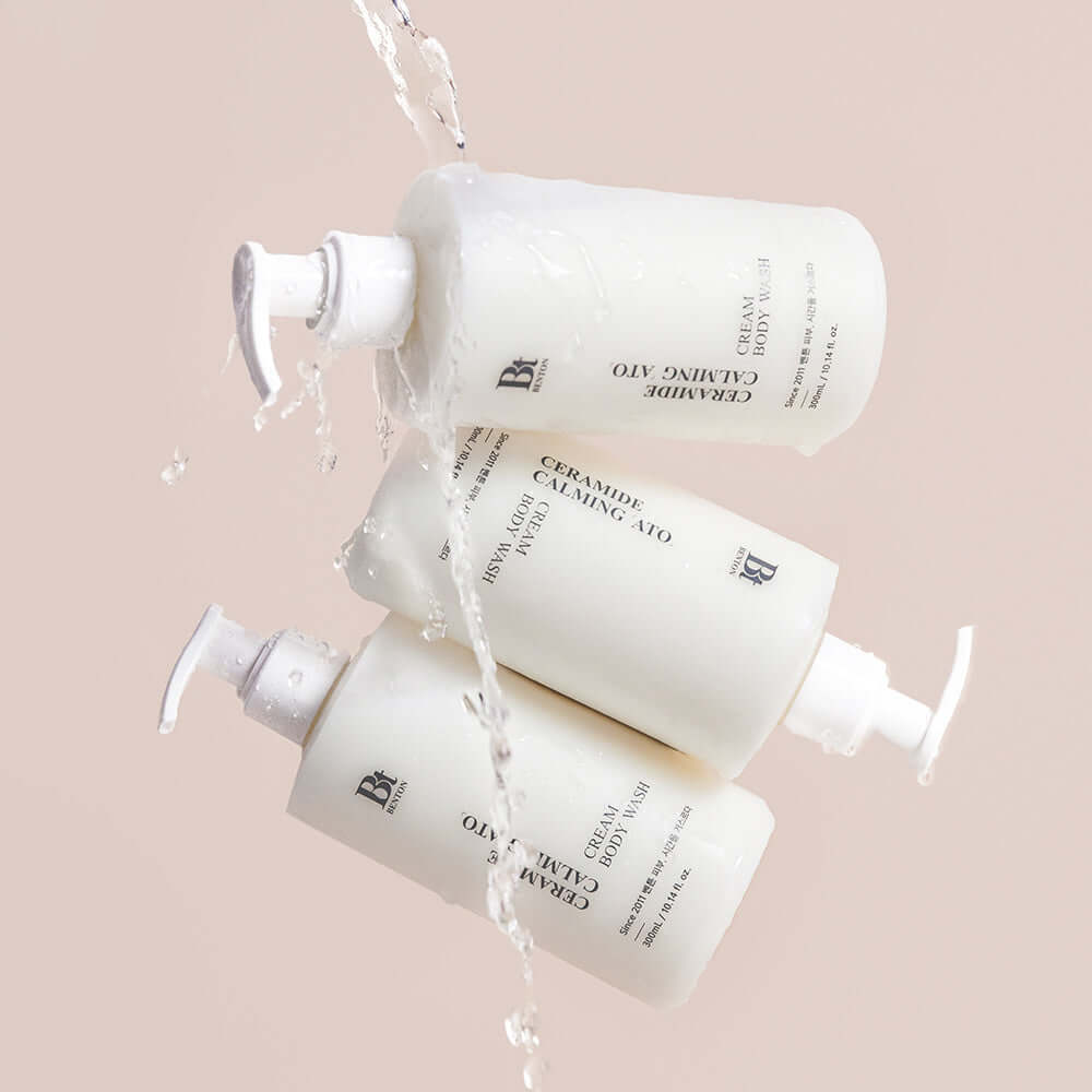 BENTON Ceramide Calming Ato Cream Body Wash 300ml bottles with water pouring over them, showcasing packaging and texture.