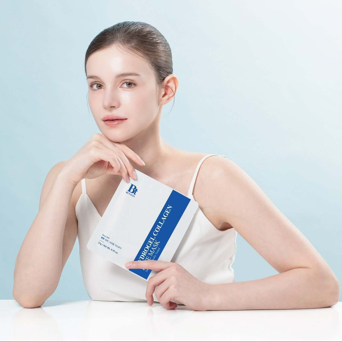 BENTON Hydrogel Collagen Mask Pack 27g x4 held by a woman in a white tank top against a light blue background