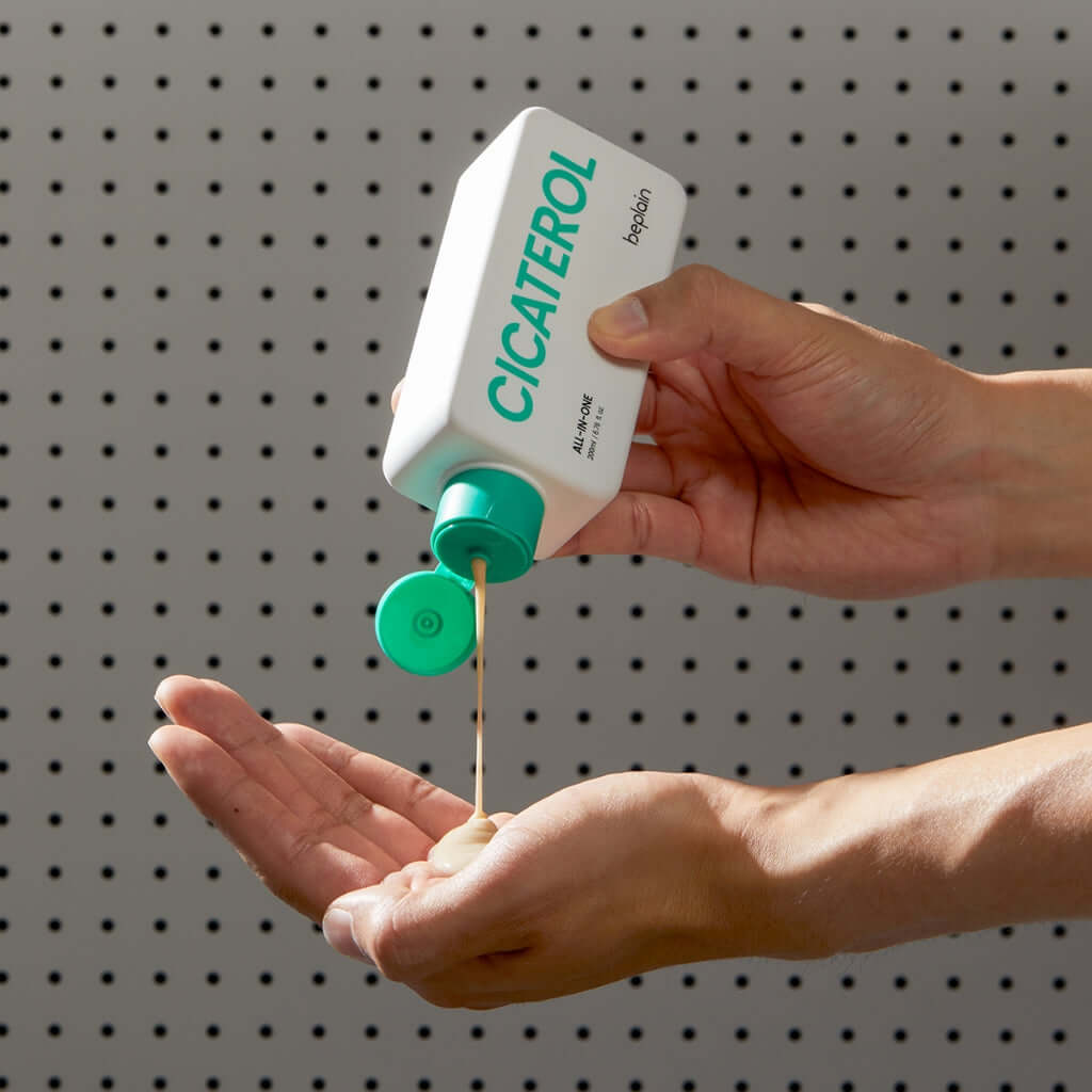 Person applying BEPLAIN Cicaterol All-in-one skincare product to hand for smooth skin.