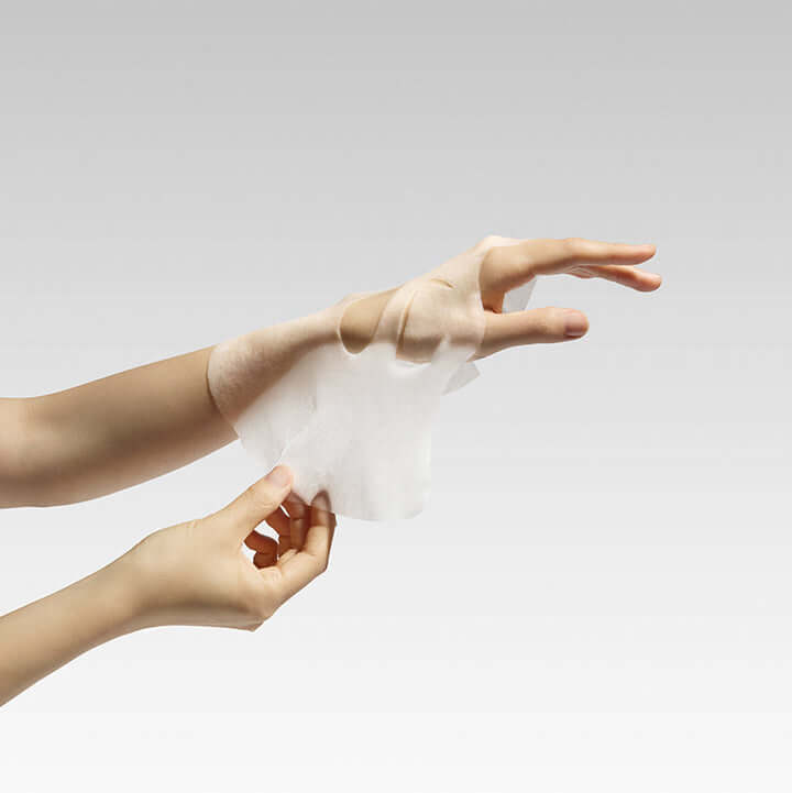 Applying BEPLAIN Green Bean Cooling And Slim Face Mask with hand showing texture and fit.