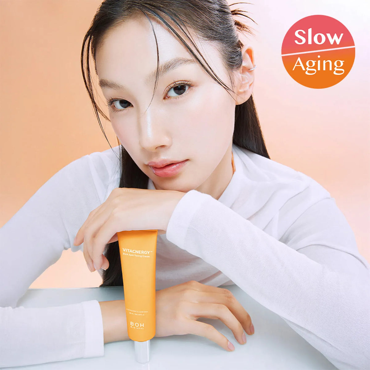 Model holding BIO HEAL BOH Vita Synergy Freckle Toning Cream 50ml for slow aging skincare benefits.