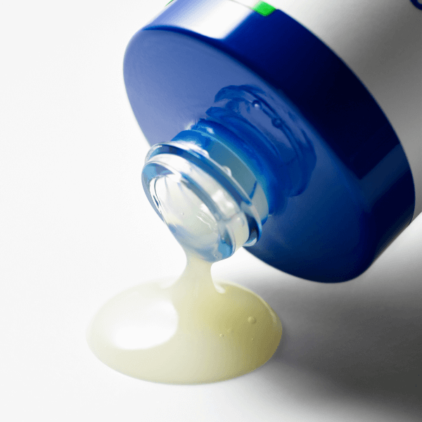 Close-up of B.READY Cicaffein trouble Reset Serum 40ml pouring from blue bottle, highlighting its texture and color.