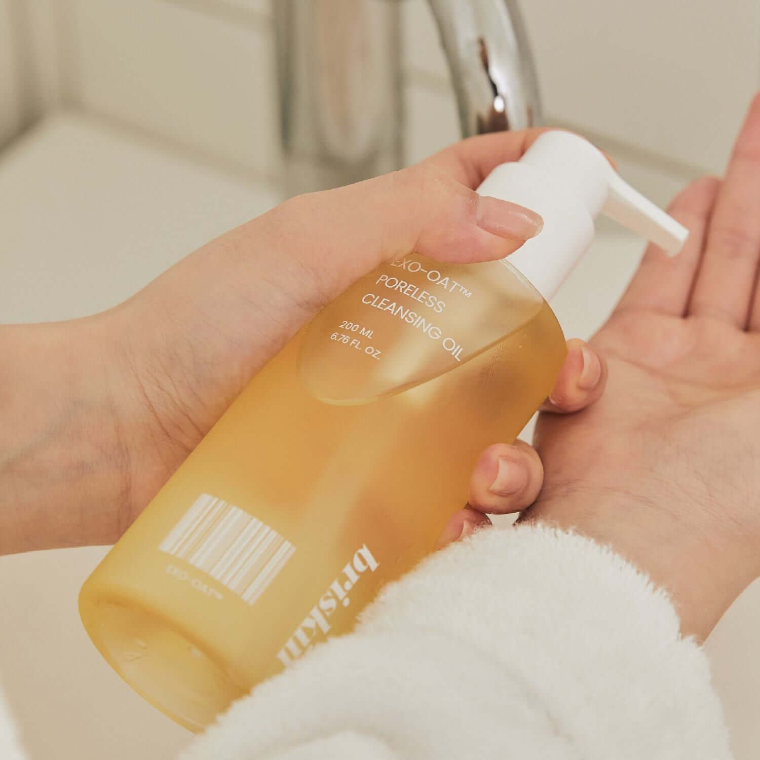 Person using BRISKIN Exo-Oat Poreless Cleansing Oil 200ml by a sink