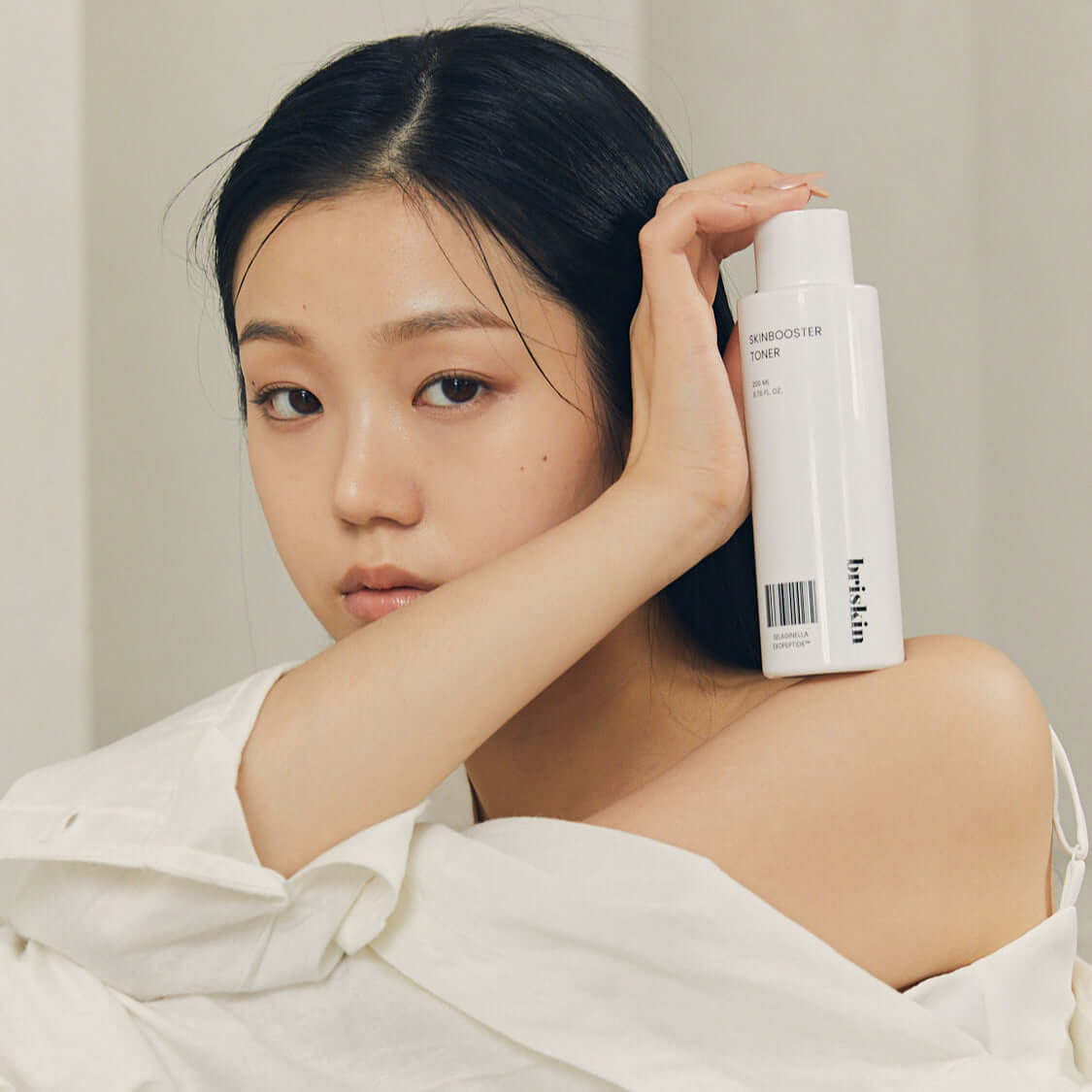 Woman holding a bottle of BRISKIN Selaginella Exopeptide Toner 200ml