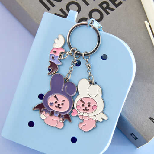 BT21 Angel & Villain Metal Key Ring featuring cute characters on a light blue background, perfect accessory for fans.