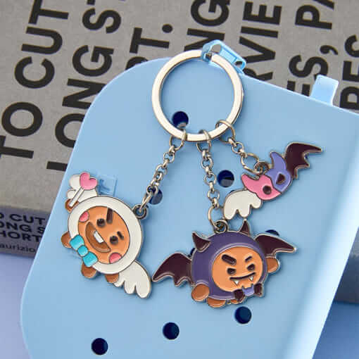BT21 Angel & Villain Metal Key Ring featuring cute angelic and villainous characters on blue background with text.