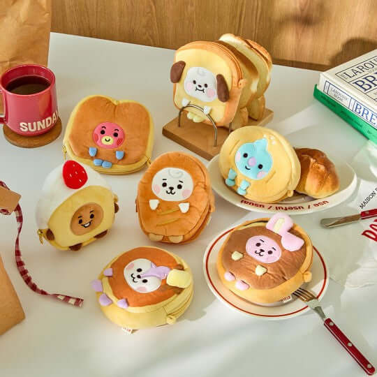 BT21 Bakery Pouch featuring cute and colorful character designs on a table with books and coffee."