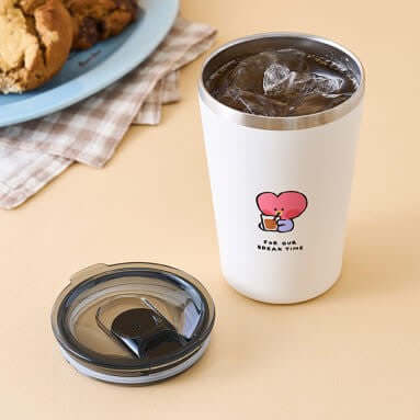 BT21 Basic Tumblr Cup 473ml with lid, featuring a cartoon design on a table with cookies.
