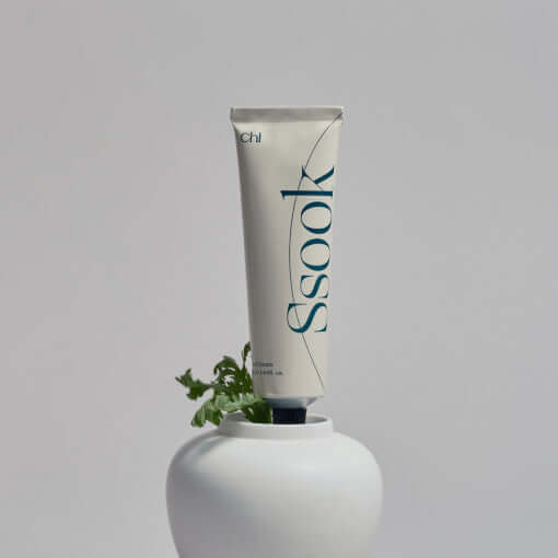 CHWI (CHI) Handcream 50ml tube in stylish packaging placed on a white pot with green plant accent, enhancing skincare ritual