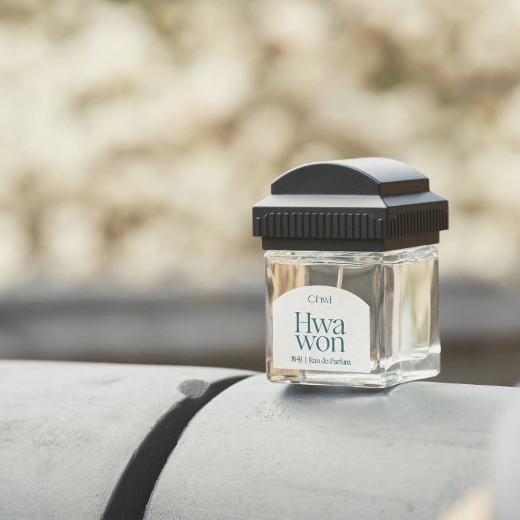 Bottle of CHWI (CHI) Hwa Won Parfume 50ml outdoors on stone surface