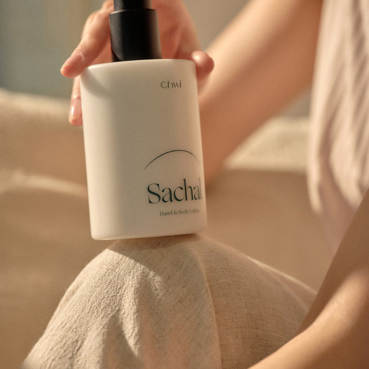 CHWI (CHI) Sachal Hand & Body Lotion 300ml bottle held by person on soft fabric background.