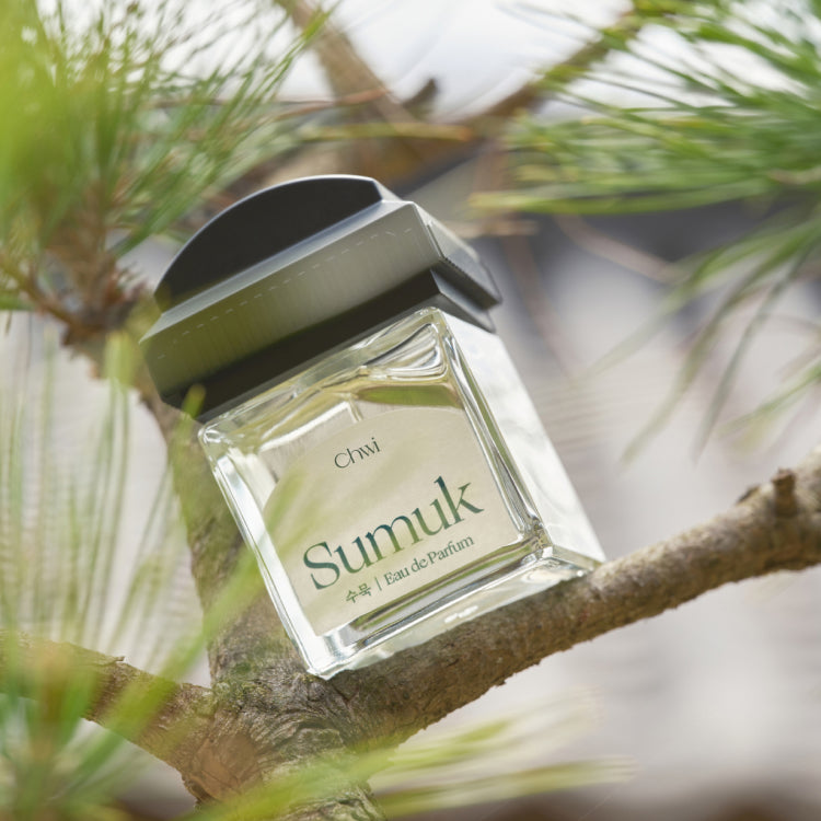 CHWI (CHI) Sumuk Parfume 50ml bottle resting on a tree branch, capturing its elegant design and natural setting.