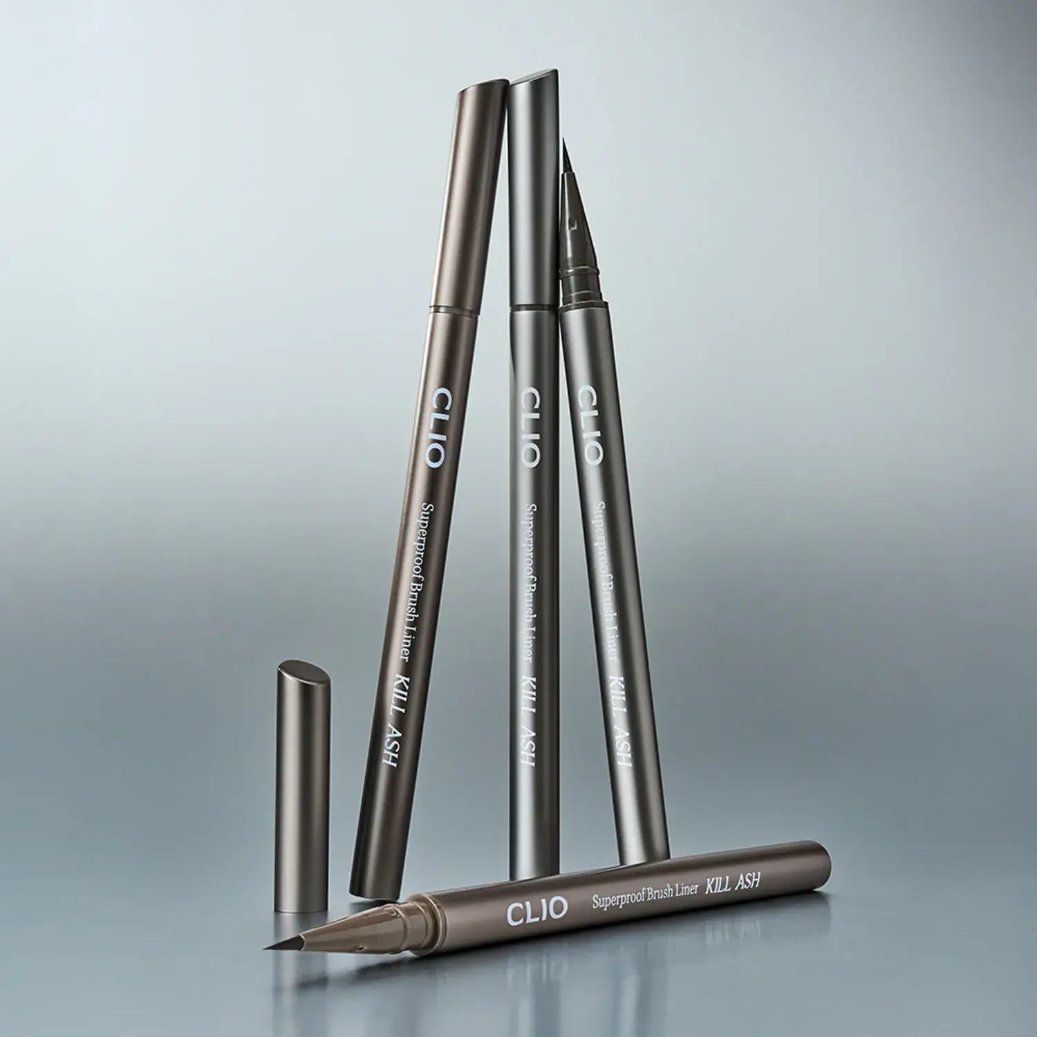 CLIO Superproof Brush Liner Kill Ash makeup collection on display against a soft gradient background.