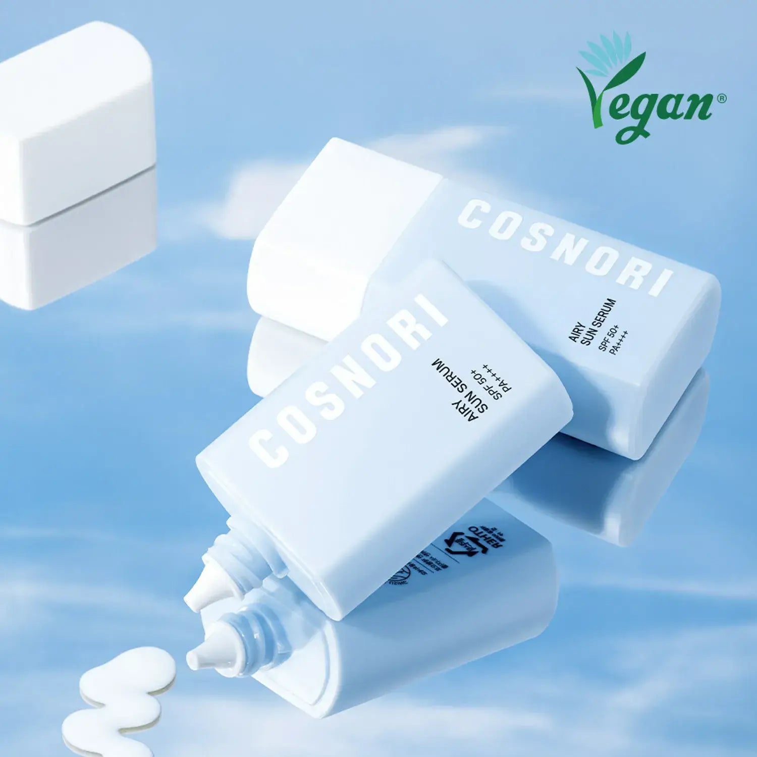 COSNORI Airy Tone Up Sun Serum bottles with vegan logo on a reflective surface