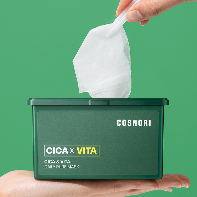 COSNORI Cica & Vita Daily Pure Mask 35ml in a container held by a hand with a vibrant green background.