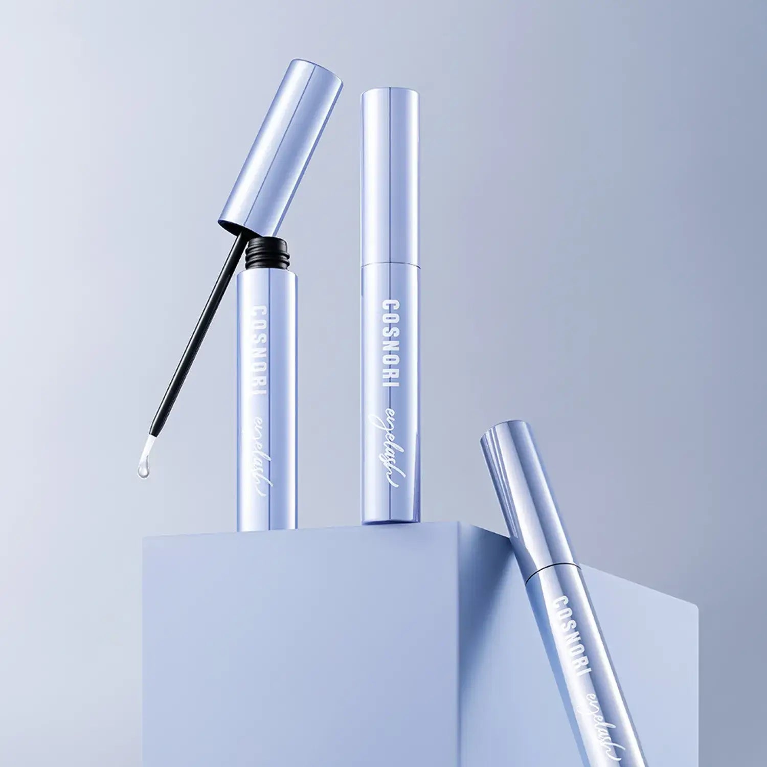 COSNORI Intensive Eyelash Serum tubes displayed on a minimalist blue background