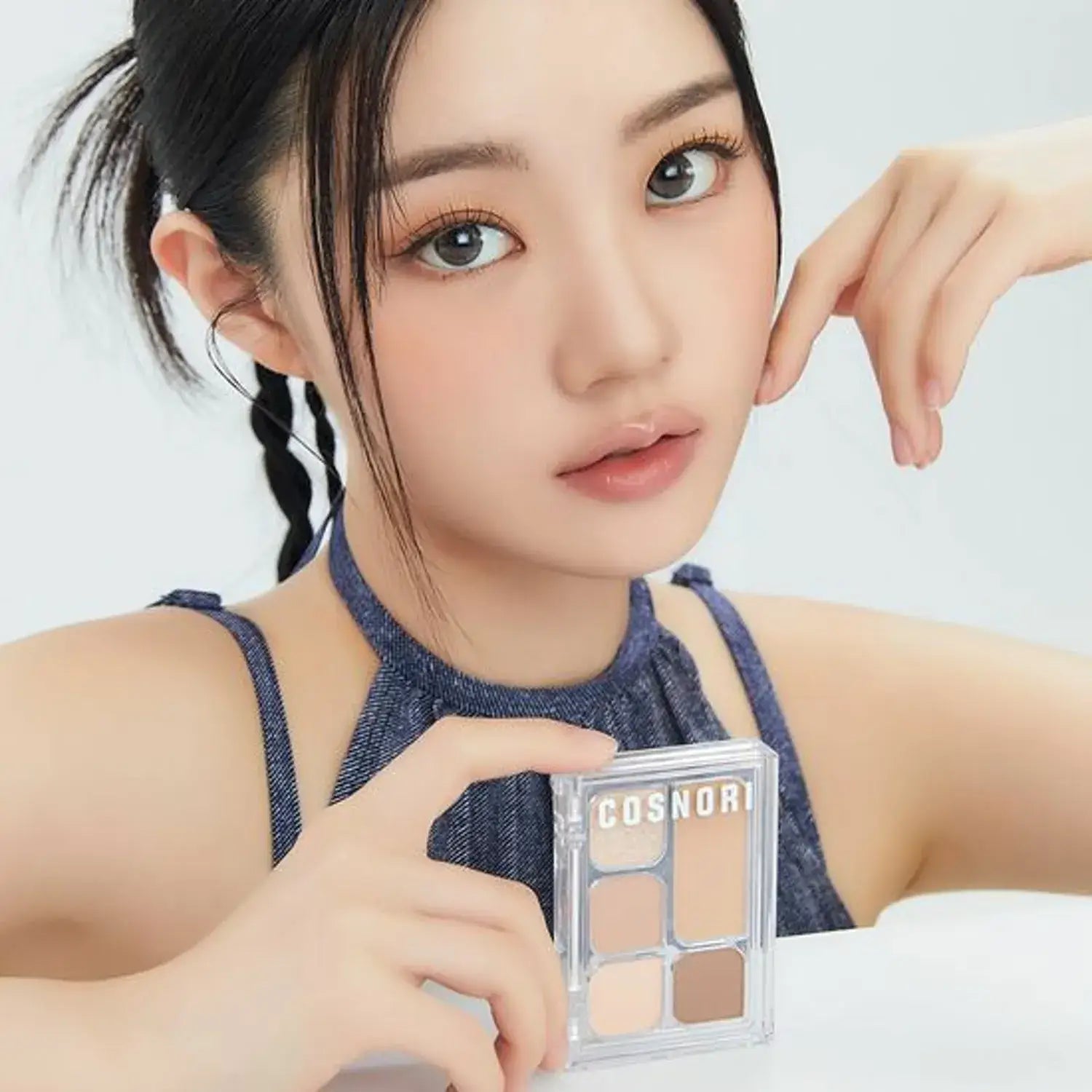 Woman holding COSNORI My Moment Eye Palette in hand, showcasing its shades for makeup application.