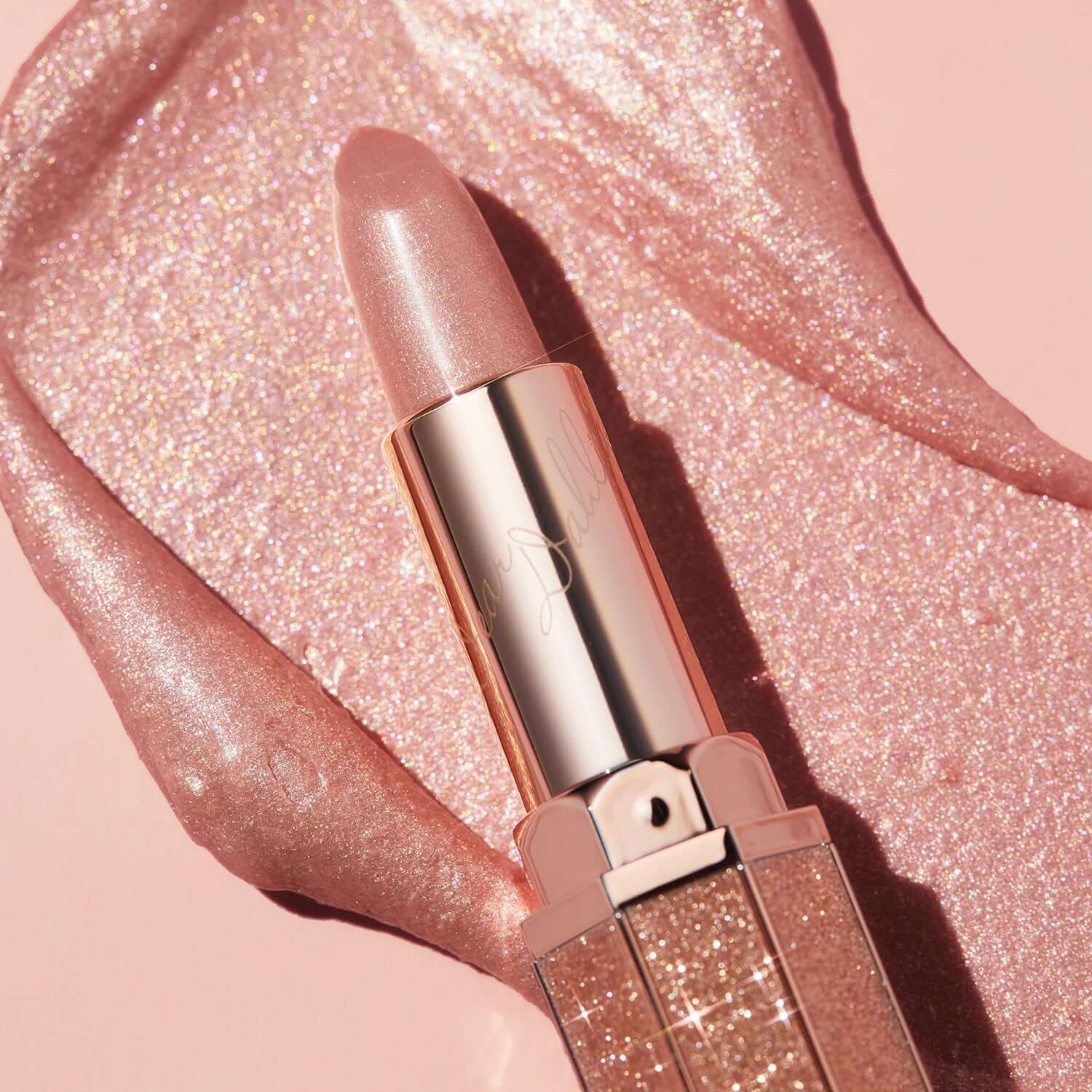DEAR DAHLIA Allure Shine Lustrous Lip Plumper showcasing its glossy finish on a pink sparkly background.