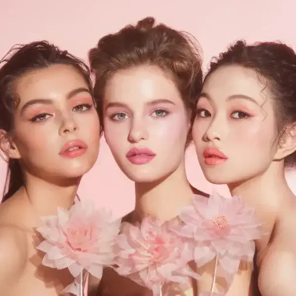 Three models showcasing DEAR DAHLIA Blooming Edition Lip Paradise Sheer Dew Tinted Lipstick with pink floral props