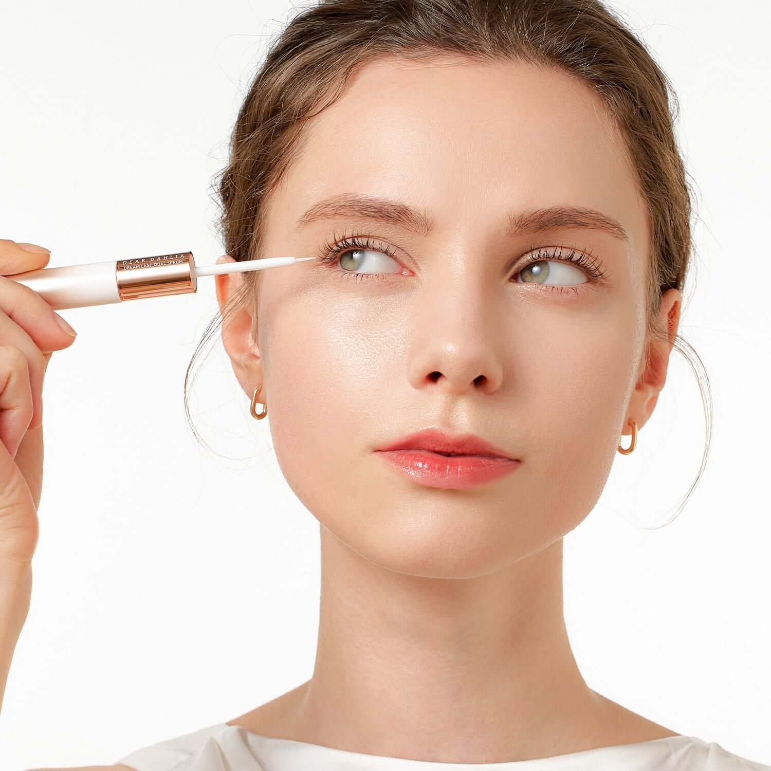 Woman applying DEAR DAHLIA Dream Lash Dual Serum to eyelashes