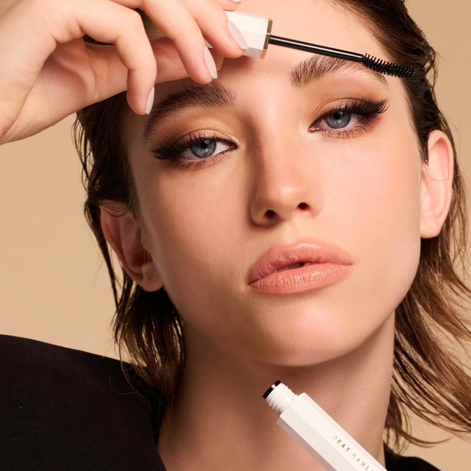Model applying DEAR DAHLIA Paradise Dream Volume & Long Lash Mascara for dramatic lash effect.