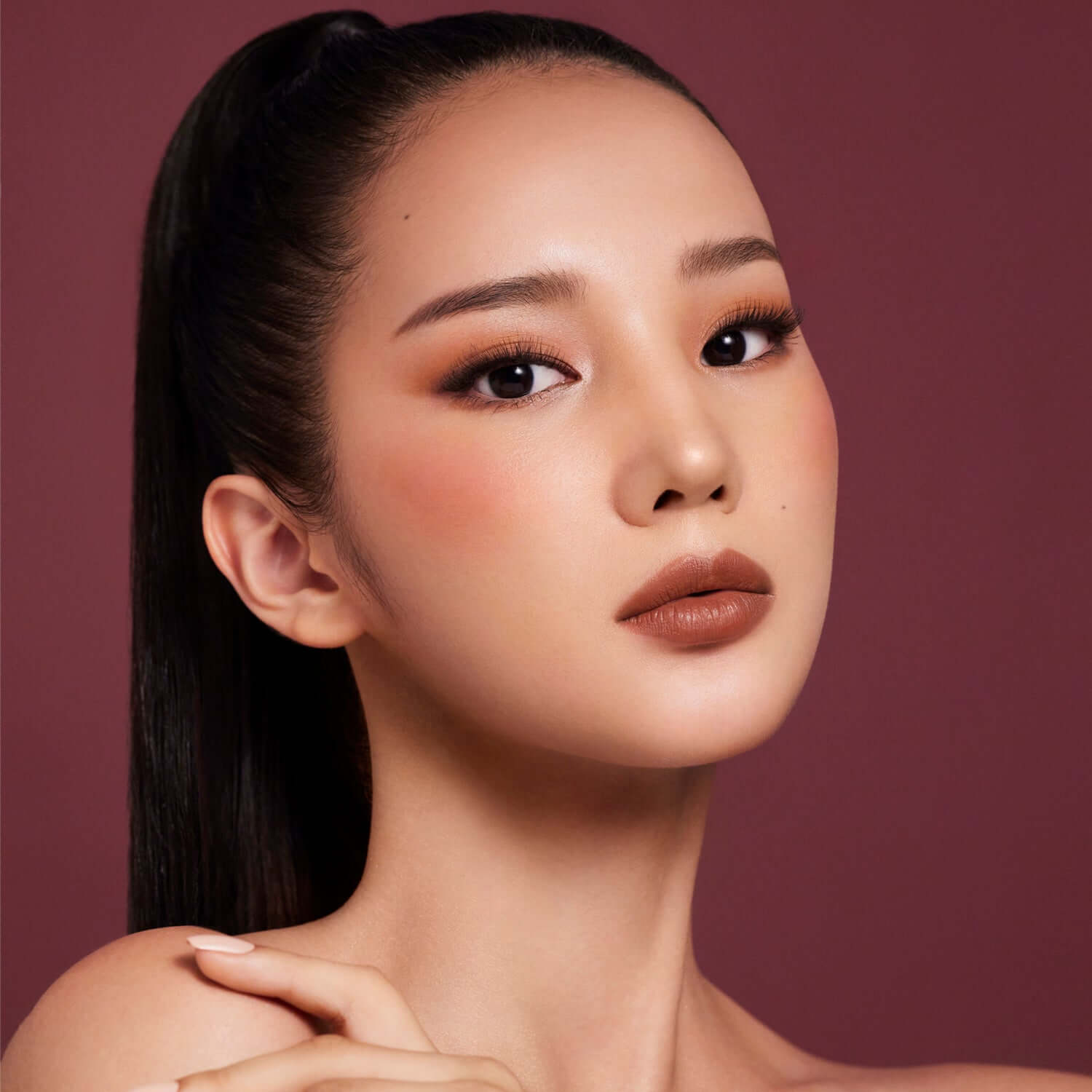 Model wearing DEAR DAHLIA Paradise Petal Matte Blush with flawless makeup look highlighting blush application.