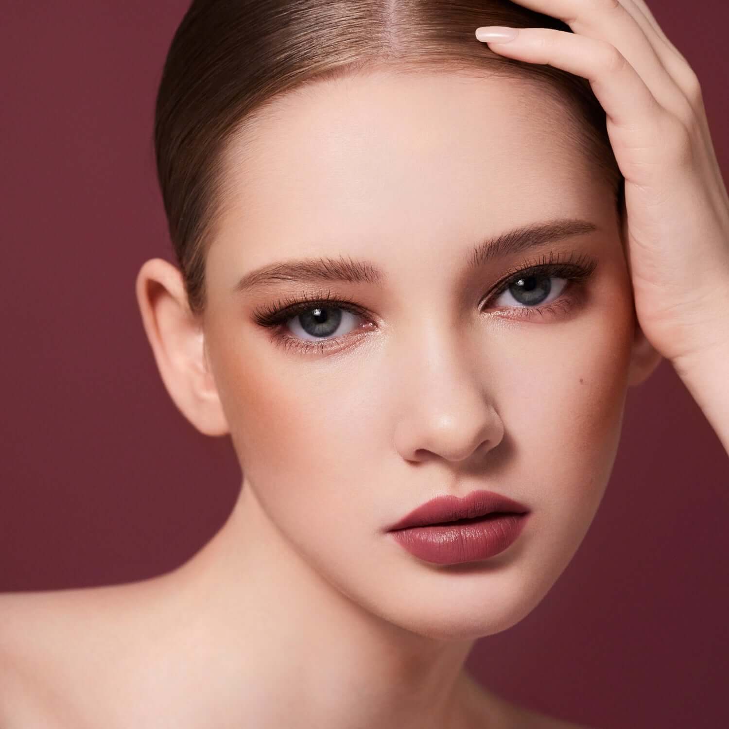 Model wearing DEAR DAHLIA Paradise Petal Matte Blush showcasing elegant matte makeup look.