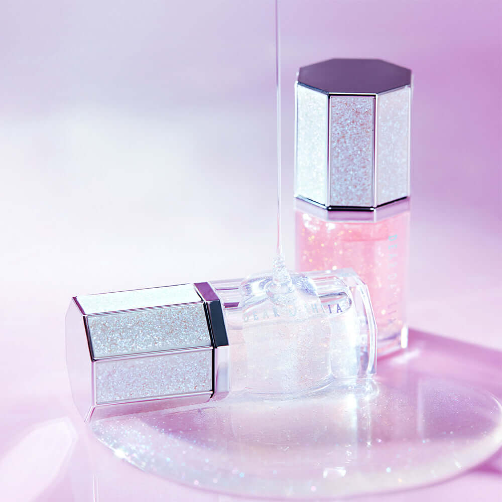 DEAR DAHLIA Paradise Sparkle Lip Glaze in elegant packaging on a pink background.
