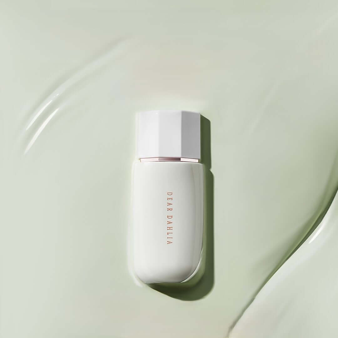 Image of DEAR DAHLIA Prime Layer Correcting Primer with elegant packaging on a green background.