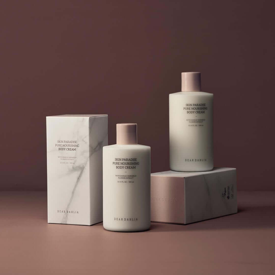 DEAR DAHLIA Skin Paradise Pure Nourishing Body Cream bottles and packaging on a brown background.
