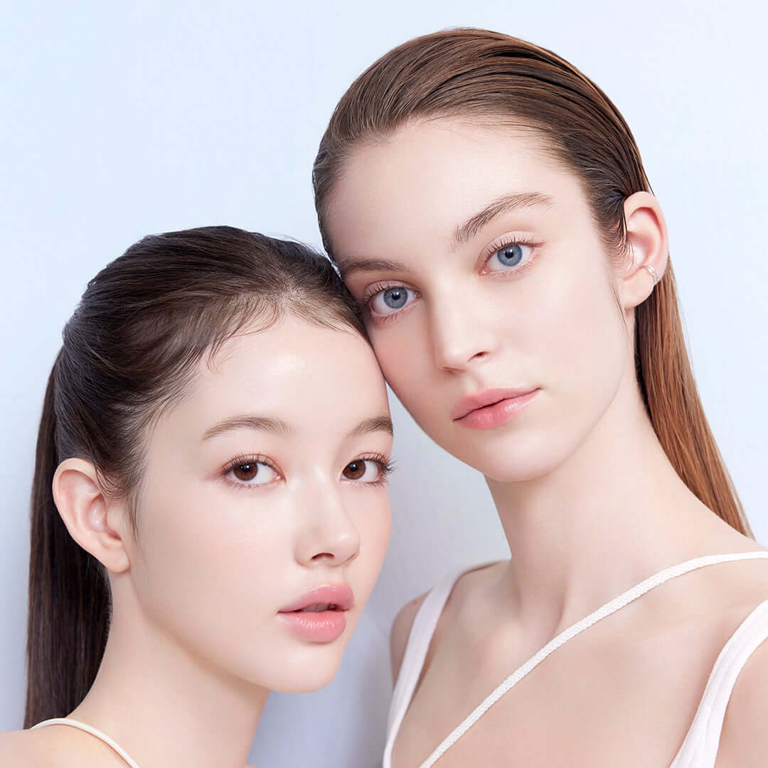 Two models showcasing the benefits of DEAR DAHLIA Sun Breeze Hydro Sun Lotion on their flawless skin.